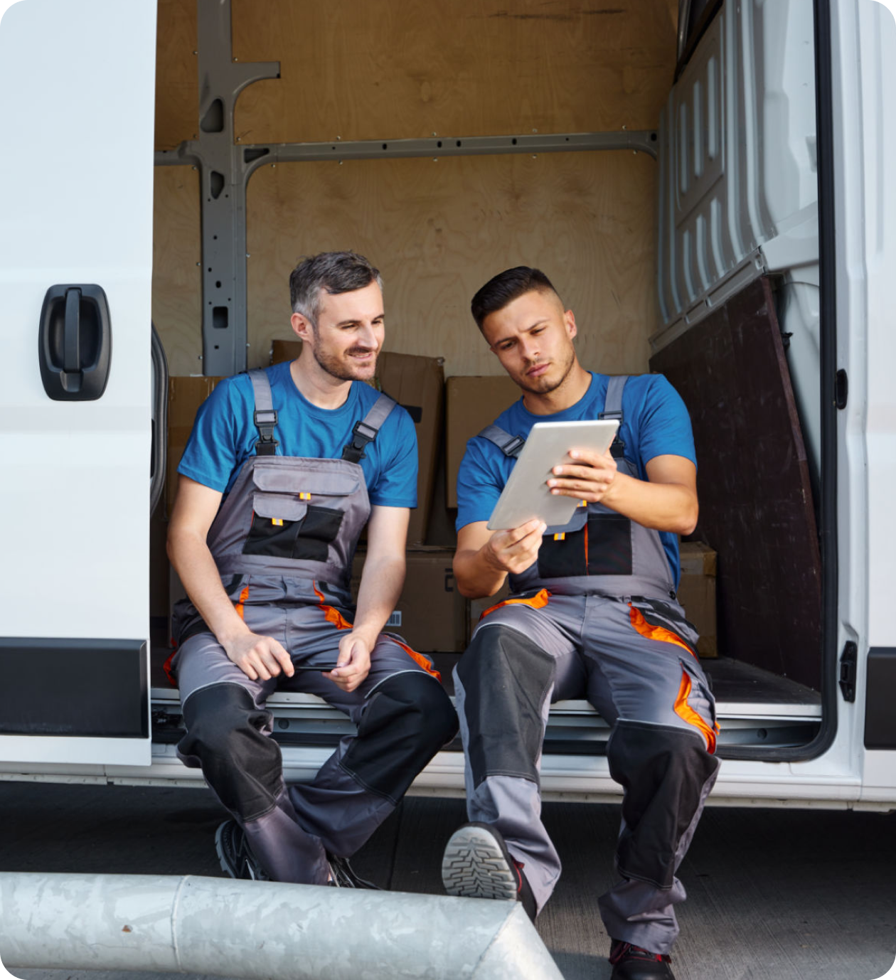 Workers sitting in van, reviewing tablet